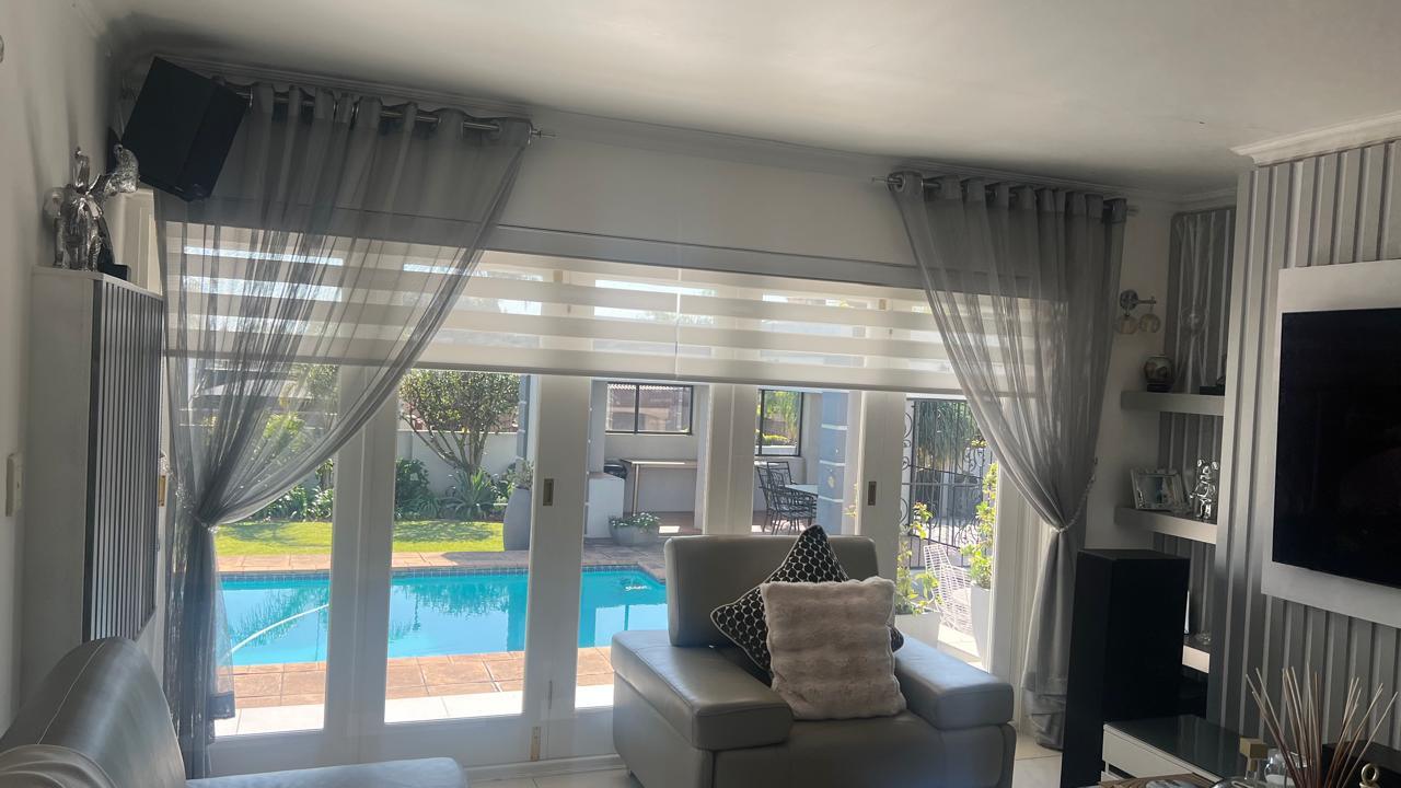 Sheer curtains layered over a roller blind, poolside lounge